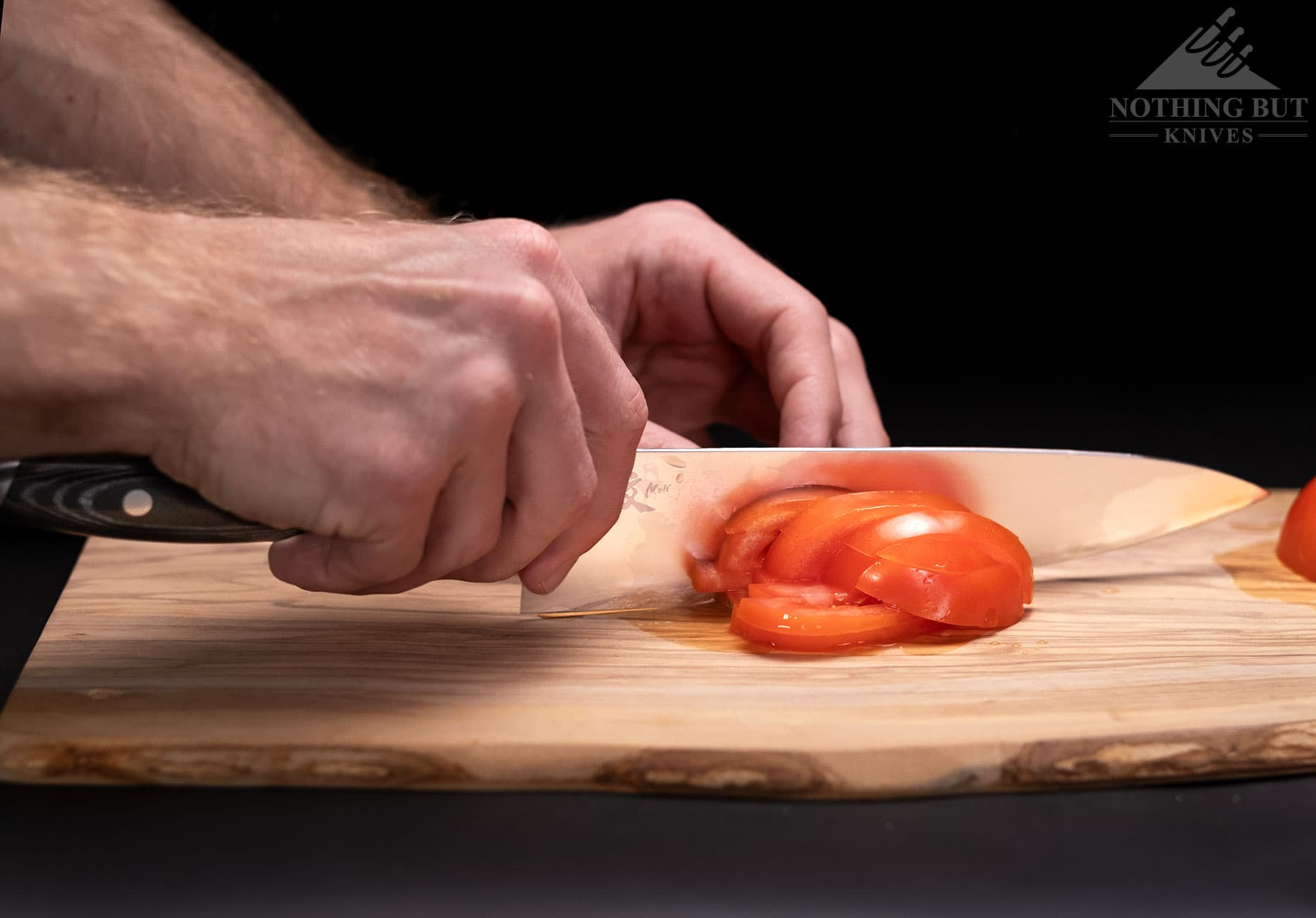 Slicing a tomato with  a Yaxell Mon kitchen knife.