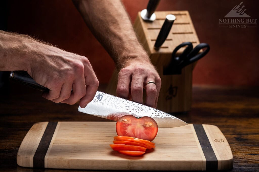 A tomato being sliced with the Japanese made Shun Premiere chef knife.