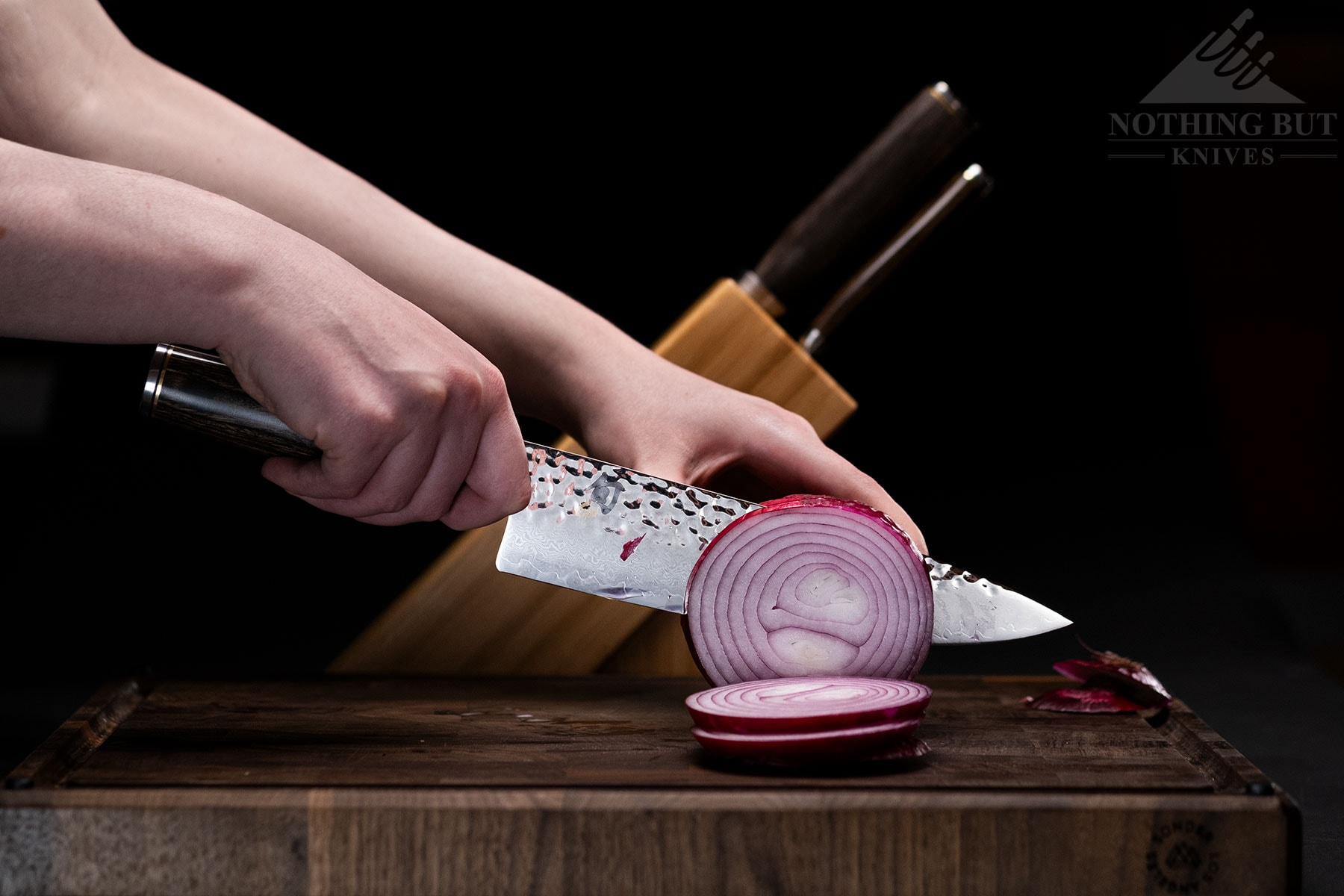 The Shun Premier chef knife being used to slice an onion in front of the 3-piece Build-A-Block set.