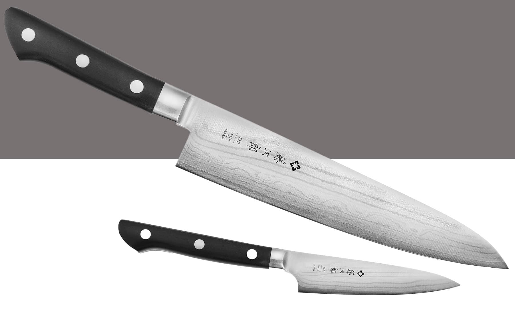 The Tojiro DP Damascus two-piece knife set shown here with the chef knife on top and the paring knife on the bottom on a split tone grey and white background. 