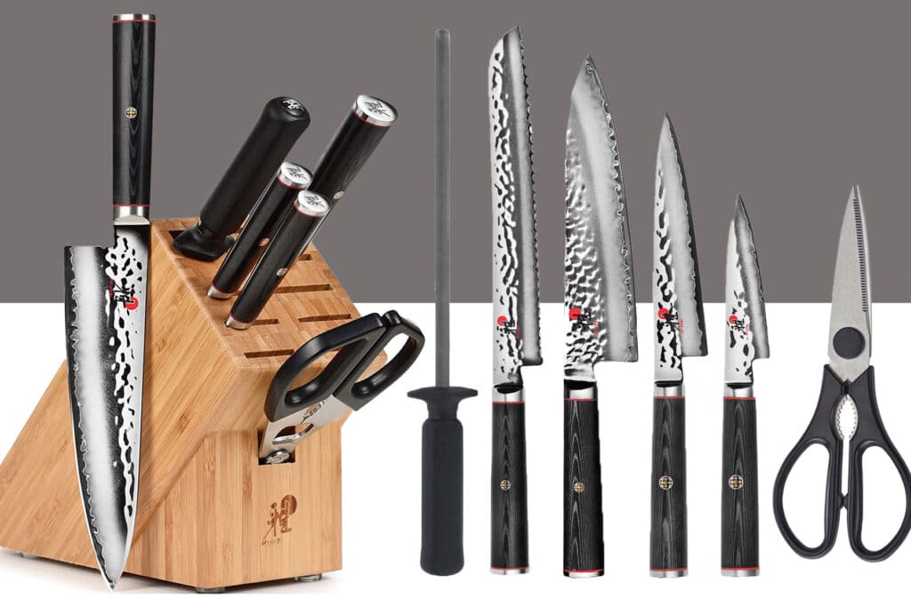 The Miyabi Mizu seven-piece knife set on a white background. Shown here with its bamboo storage block on the left and all the included knives on the right.