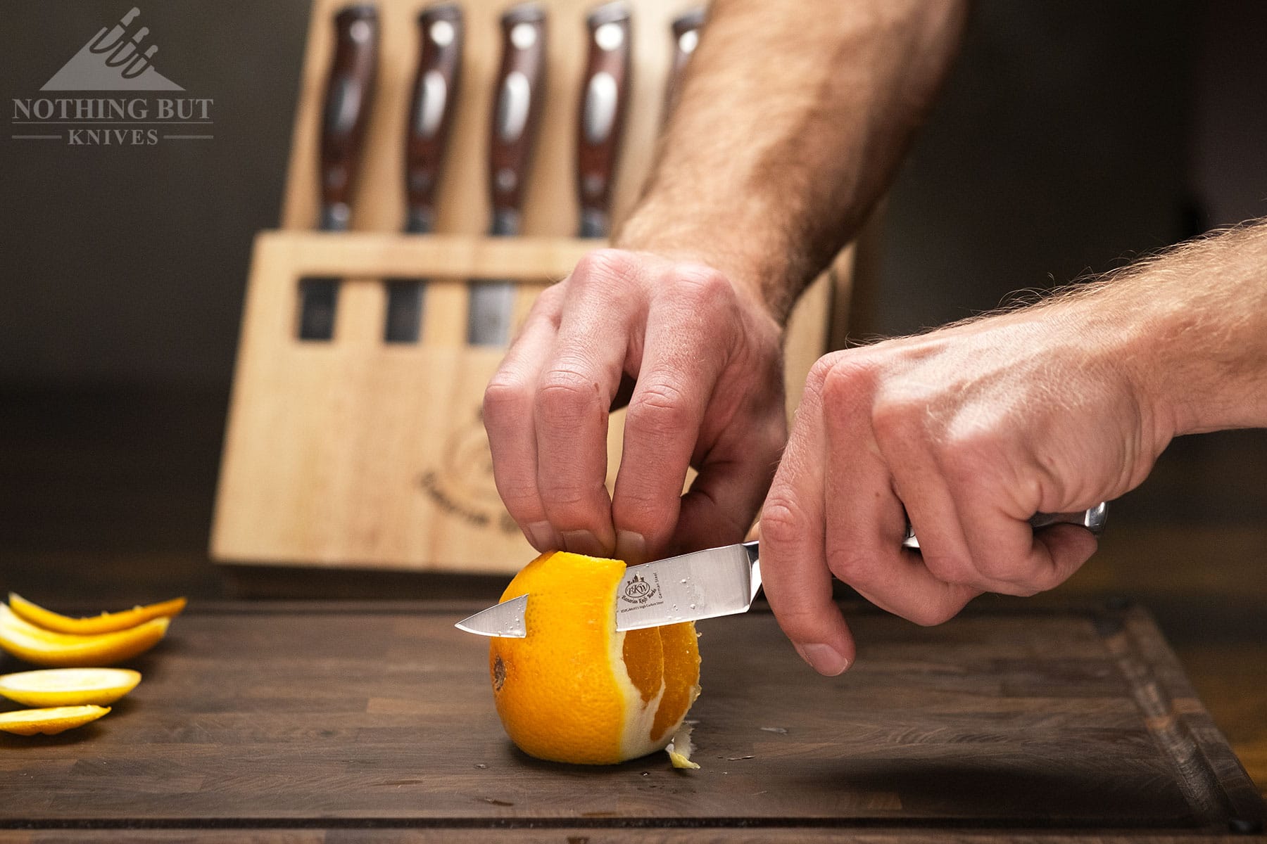 A close-up of a paring knife being used to peel an orange during the long process of testing the Bavarian Knife Works set.