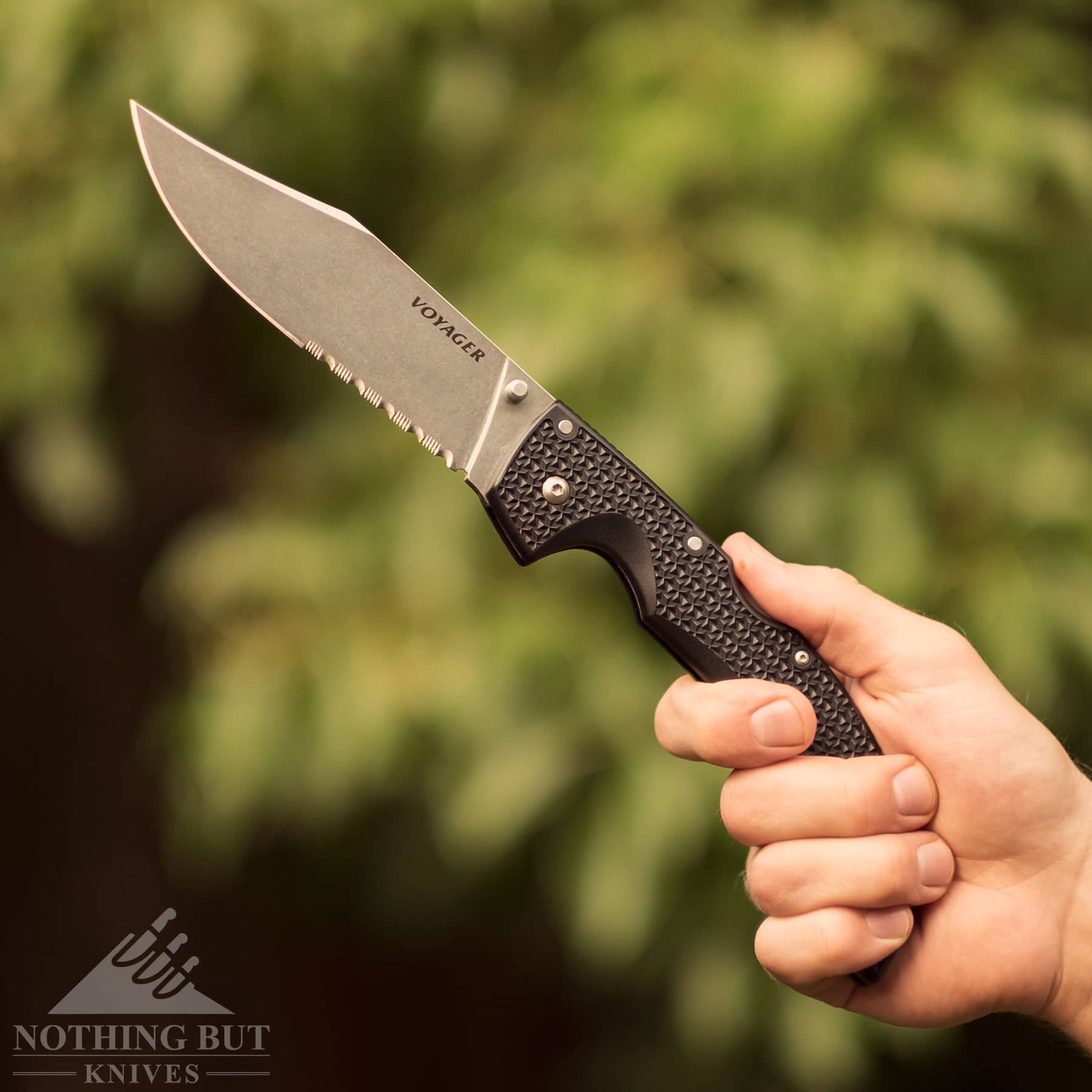 A person's hand gripping the rear section of the Voyager XL handle to show how versatile the knife is. 