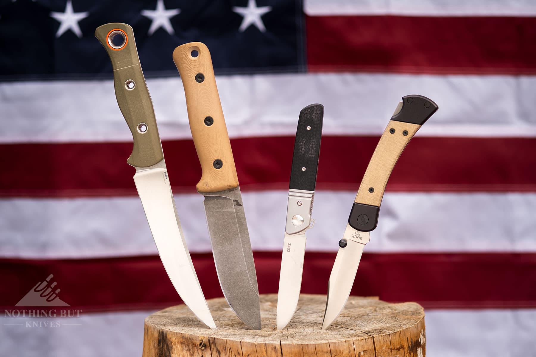 Four USA made knives sticking out of a log in front of an American flag.