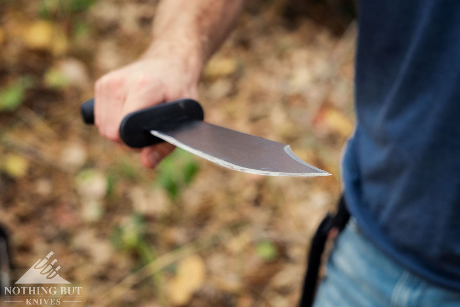 A close-up of the Cold Steel Black Bear Bowie blade with its edge facing the camera to show the grind.