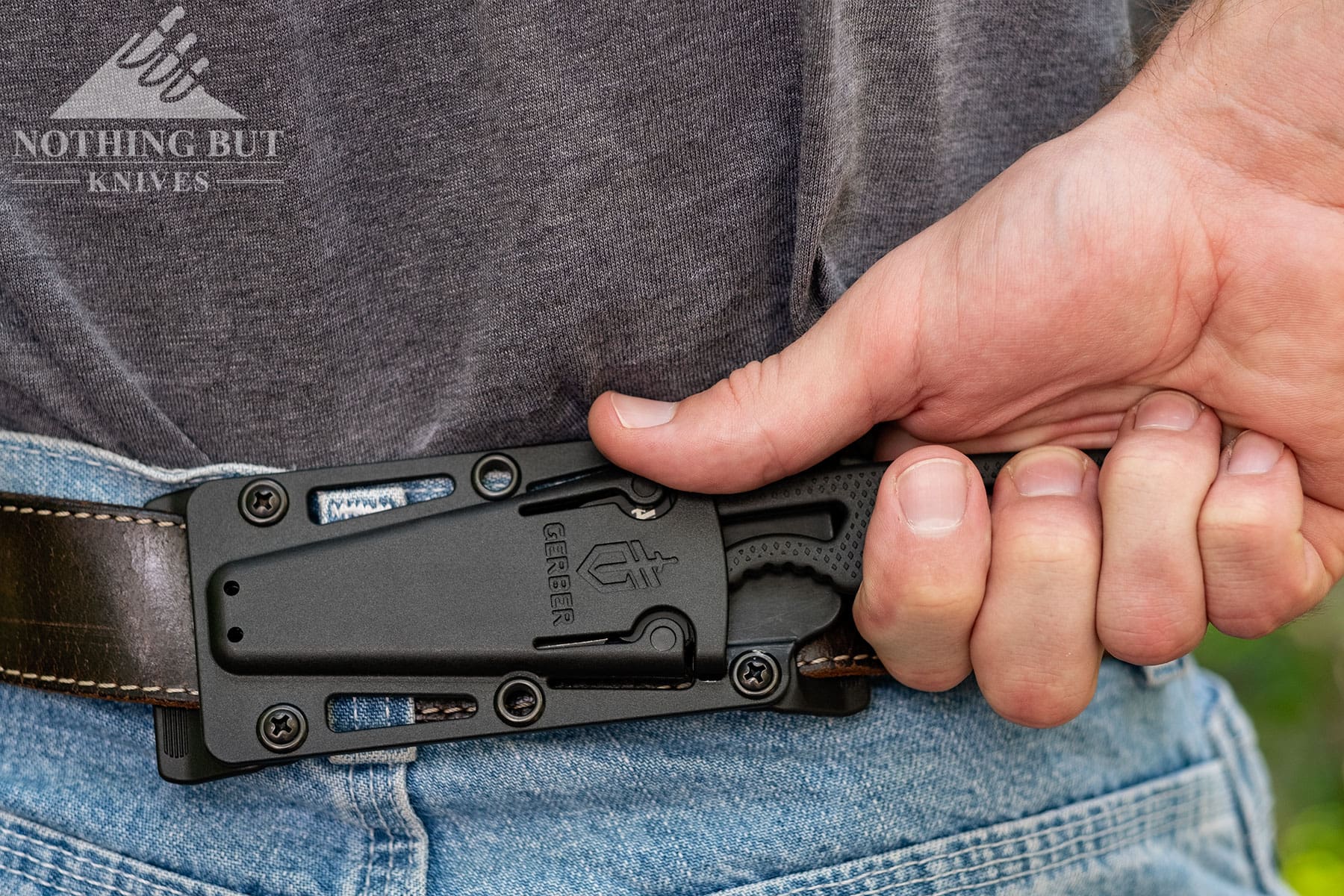 A person deploying the Gerber Ghostrike from its sheath in the horizontal carry position. 