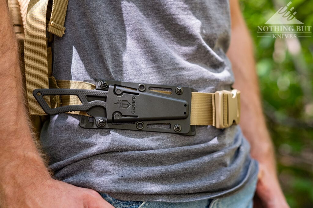 The Gerber Ghostrike fixed blade knife attached to the waist strap of a person's backpack.