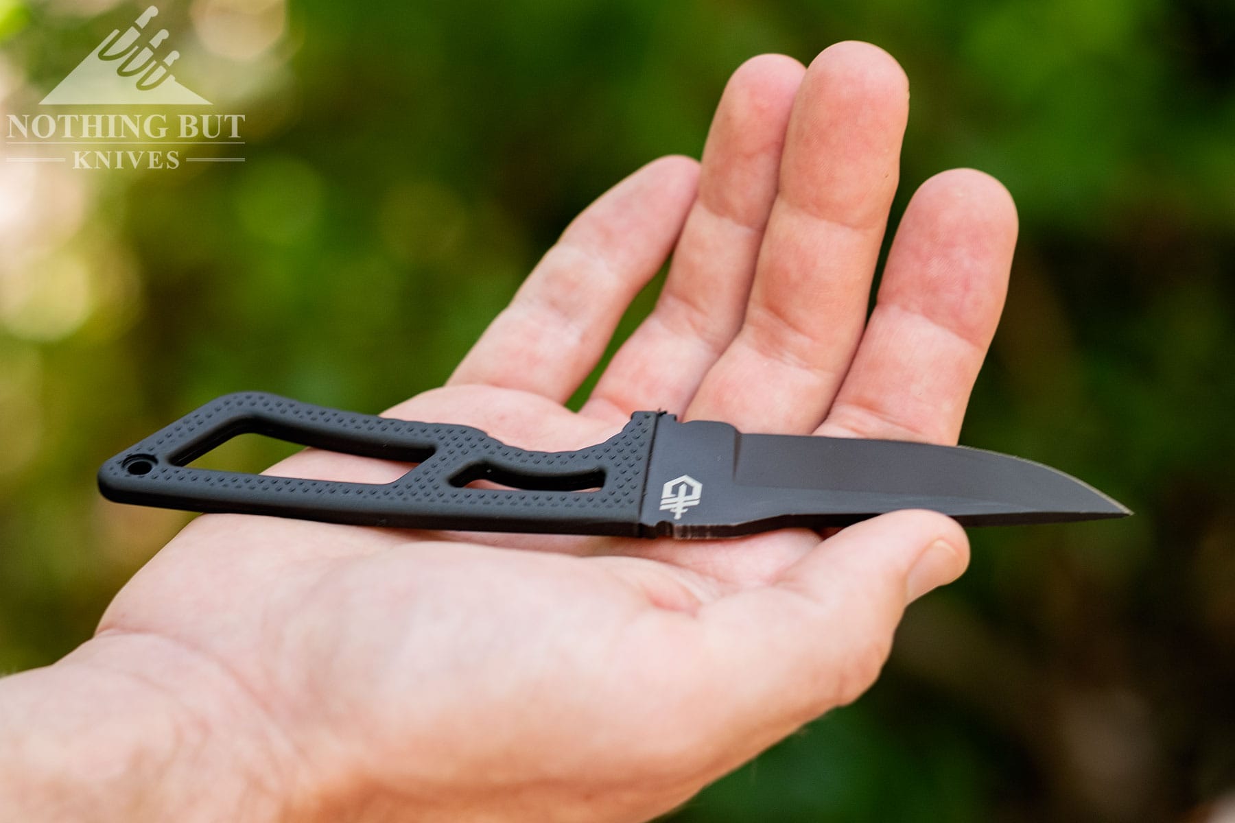 The Gerber Ghostrike in the palm of a person's right hand to show scale.