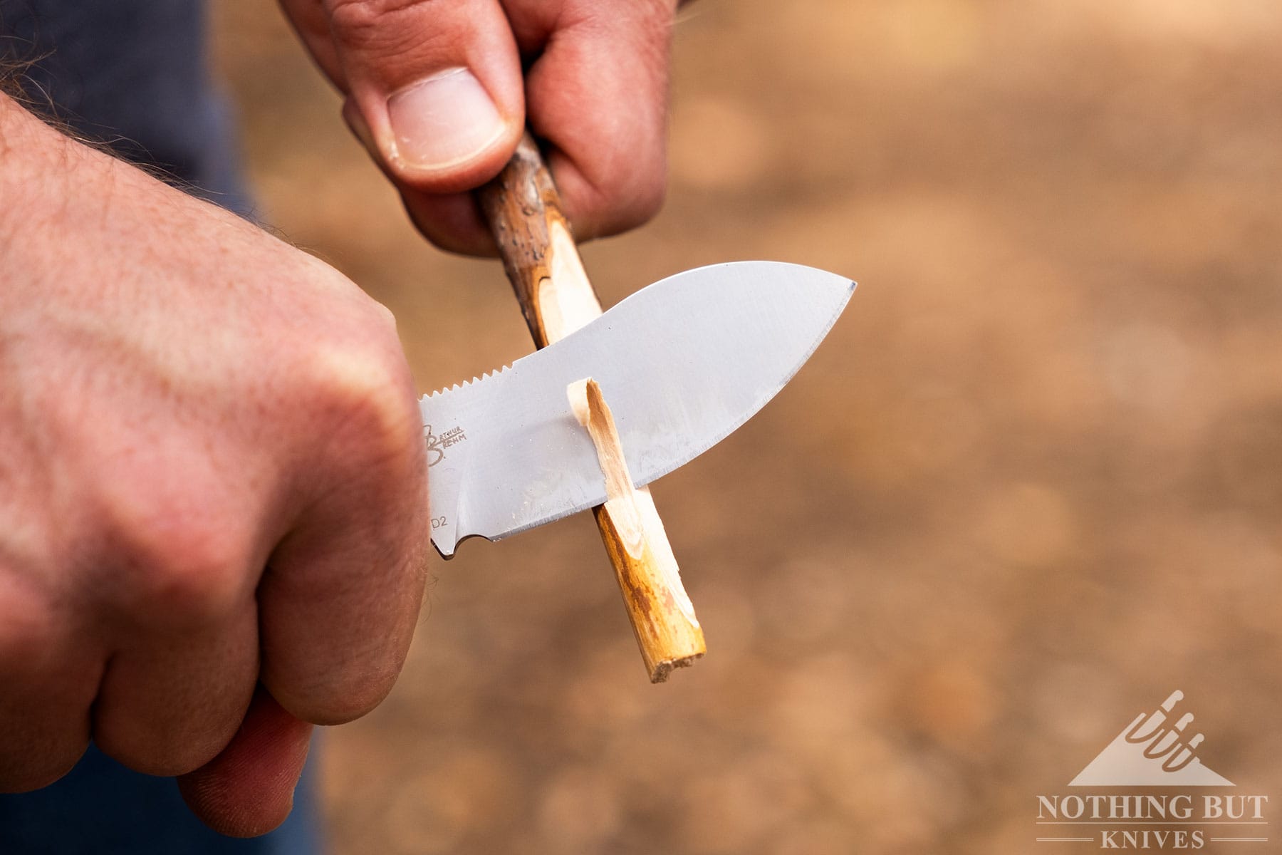 A shallow depth of field close-up of the QSP Neckmuck blade carving a sitck .