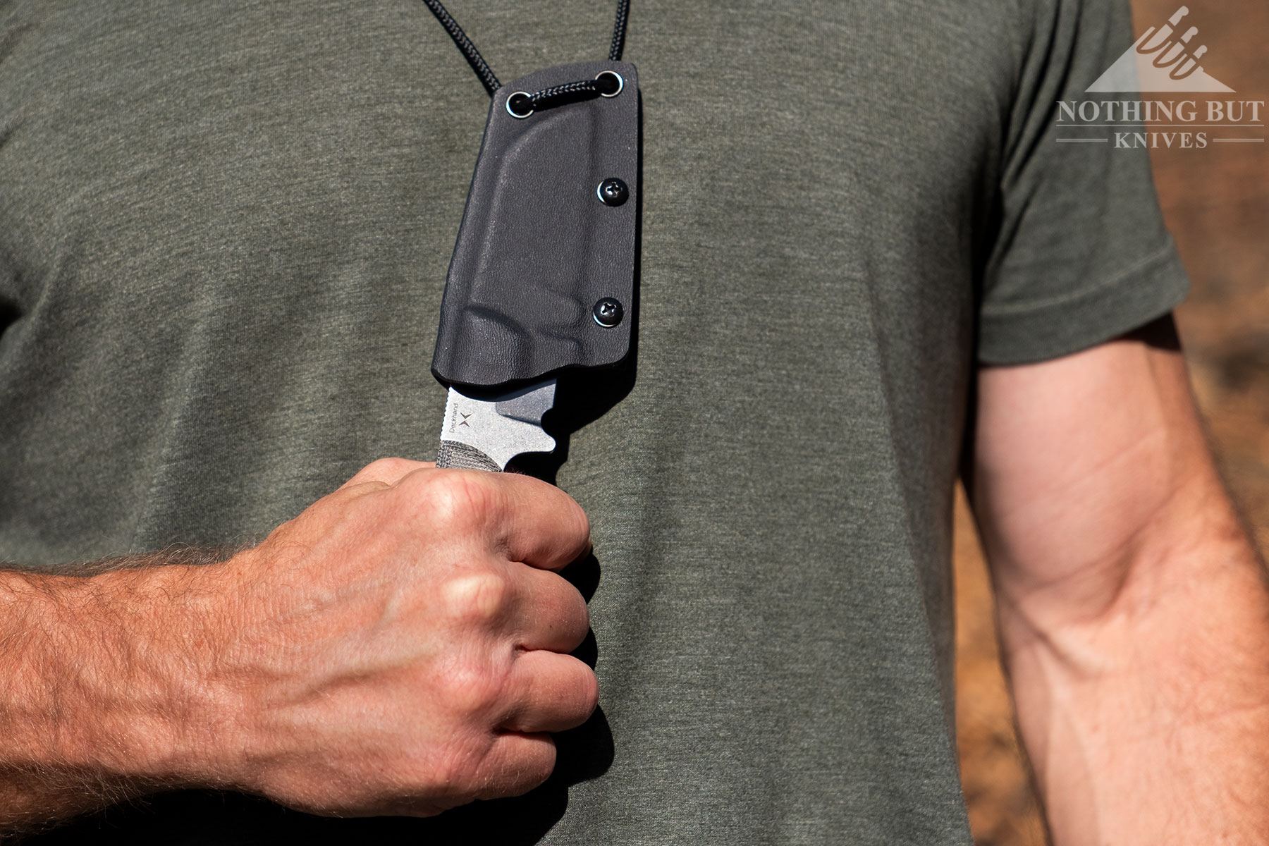 A close-up of the Kizer Deckhand D2 knife being deployed from its sheath while worn on a person's neck. 