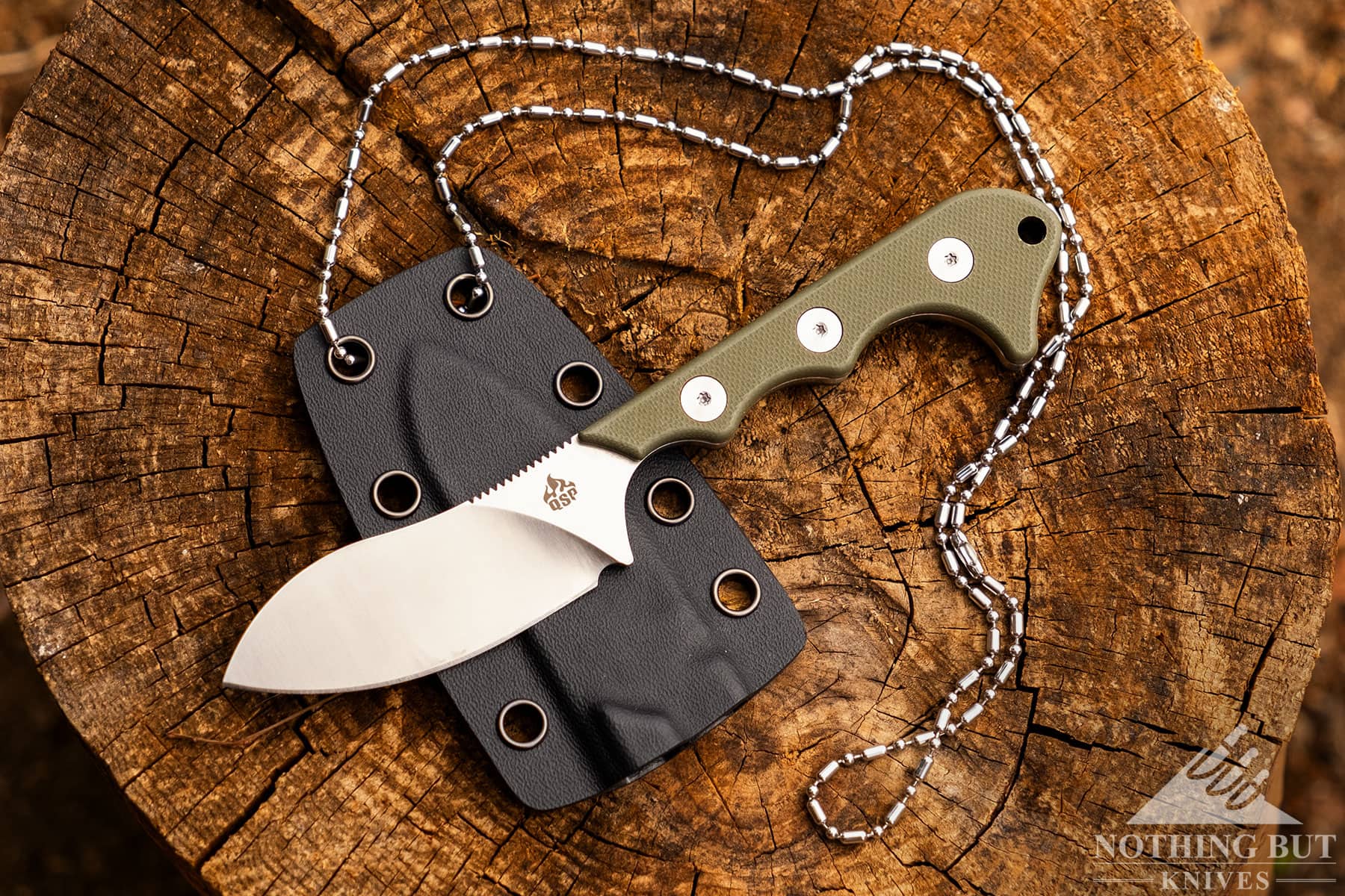 An overhead view of the QSP Neckmuck fixed blade neck knife on top of its kydex sheath.