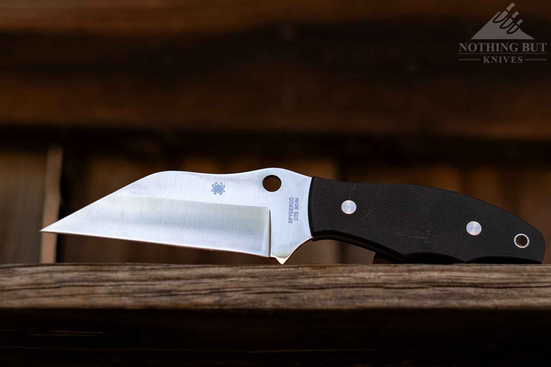 The Spyderco Ronin 2 Tactical fixed blade sitting on a fence outdoors. 