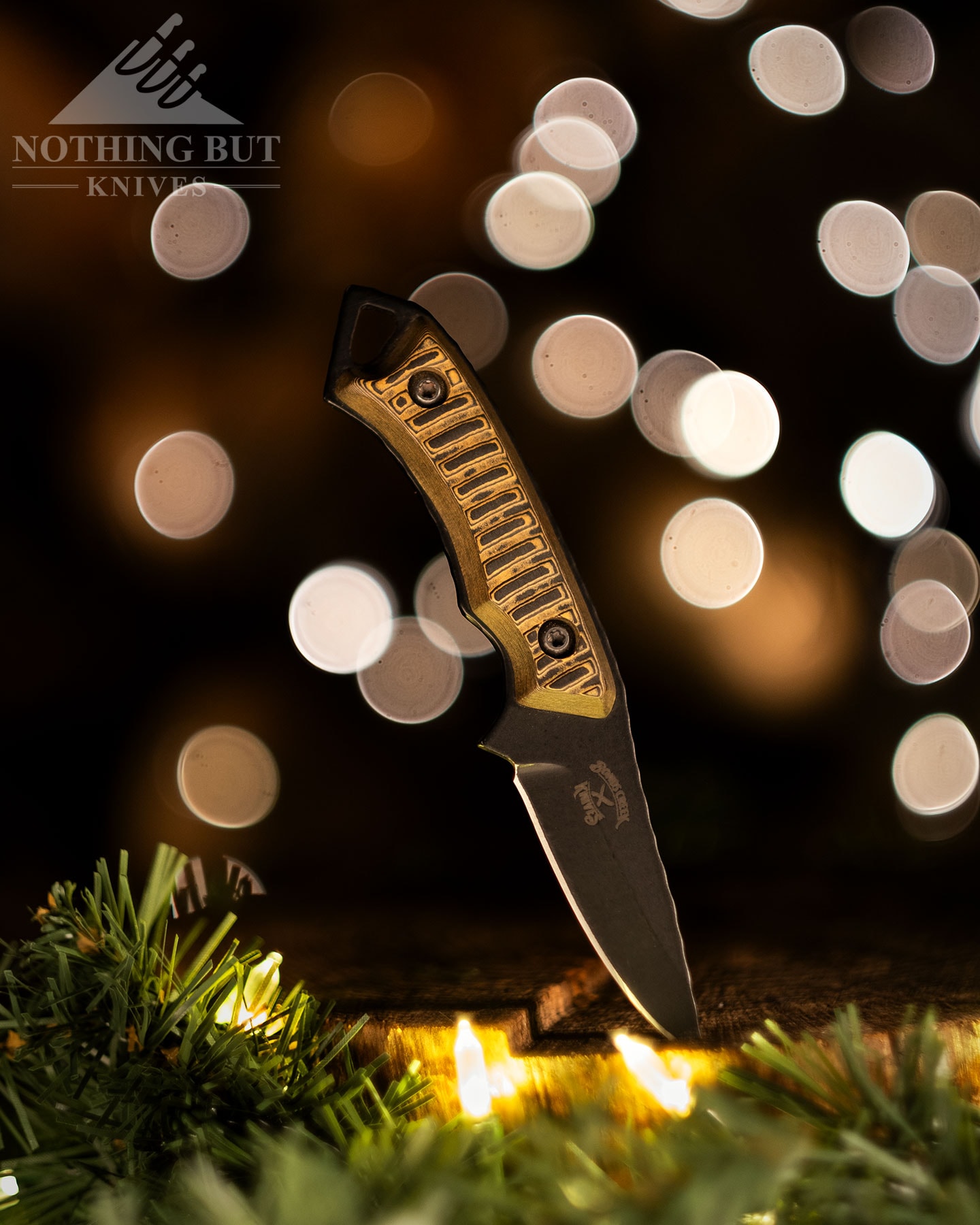 The Bonds Creek Badger EDC fixed blade knife sticking out of a tree stump that has been decorated for Christmas . 