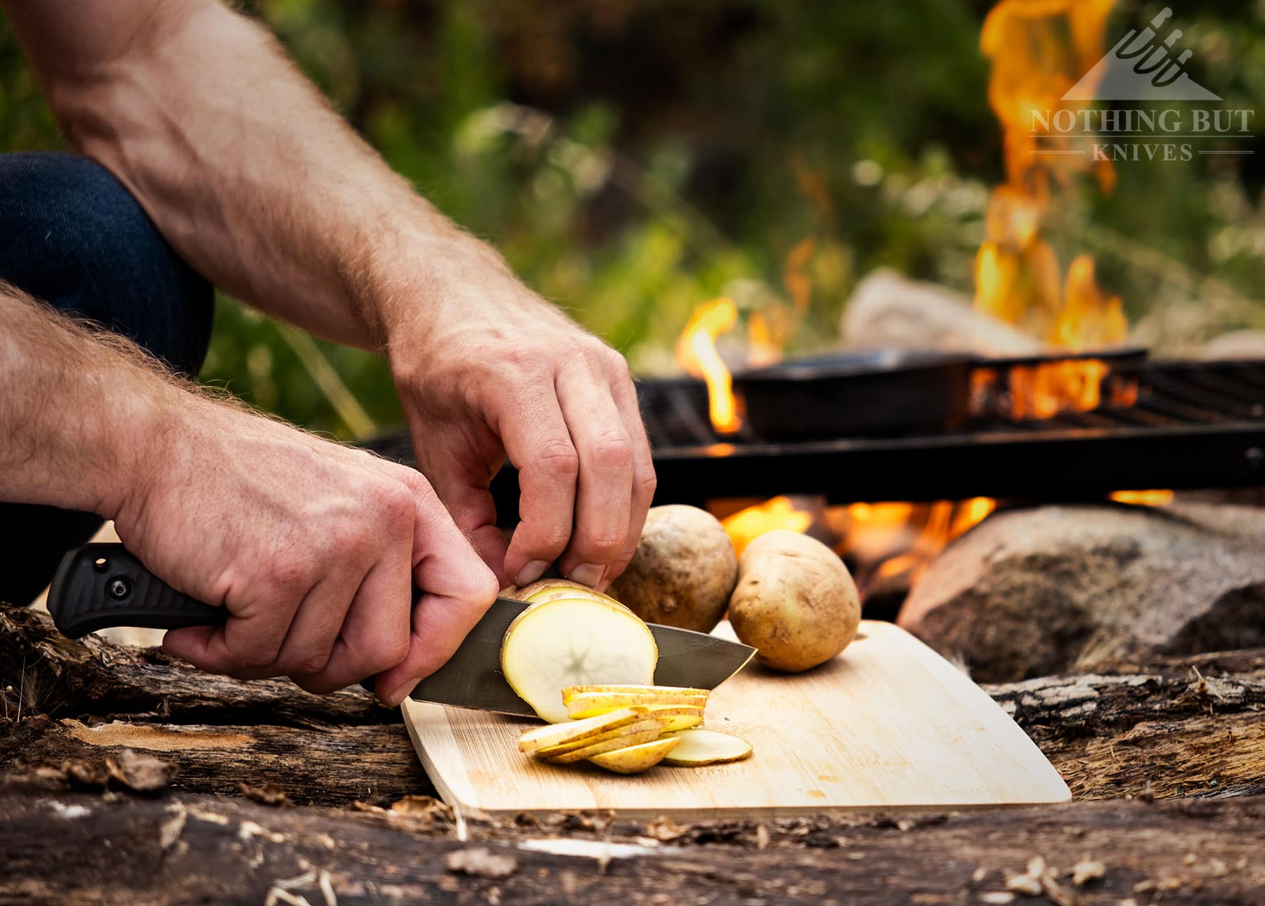 The Schwarz Lost Trail 5 is a 2024 knife release seen here being used to slice a potato next to a campfire.  