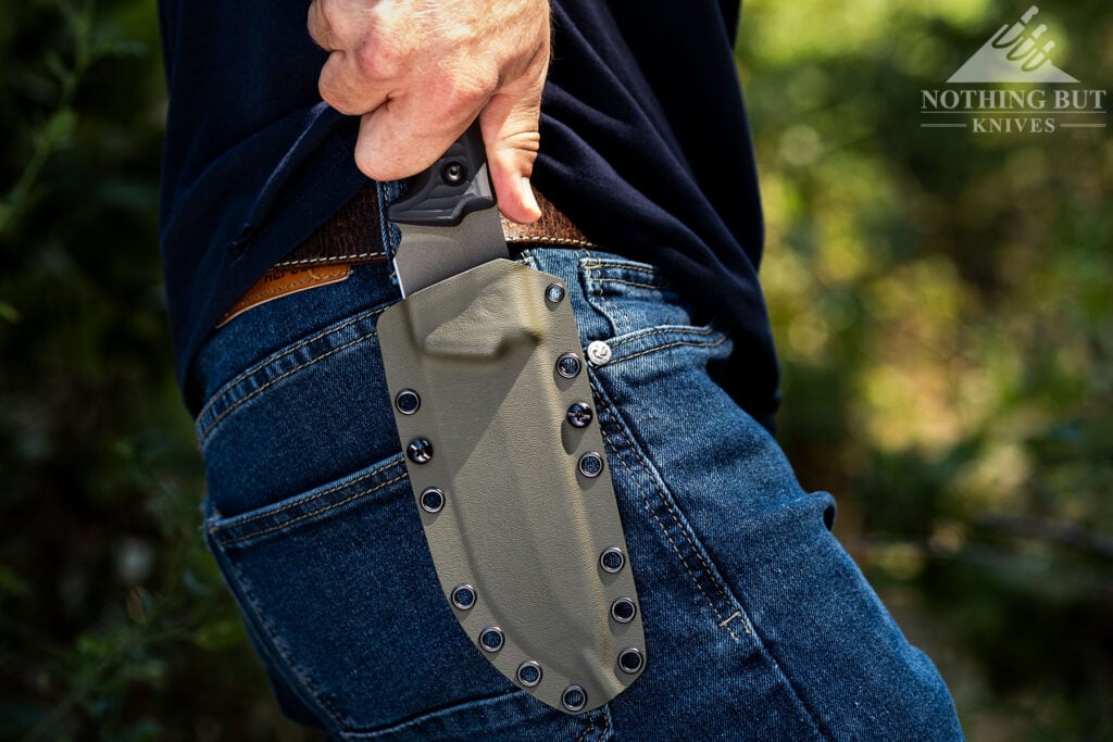 A close-up of the Schwarz Lost Trail 5 fixed blade knife being deployed from its sheath.