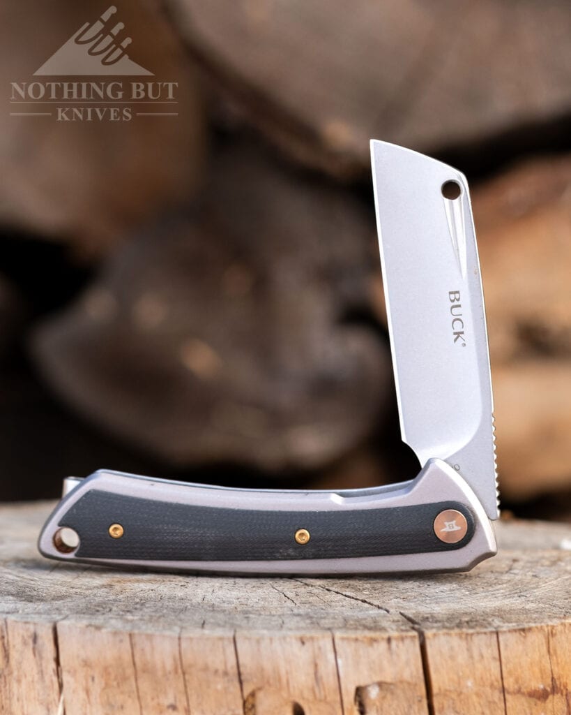 The Buck Hiline pocketknife with a D2 steel blade in the half open position on a piece of firewood. 