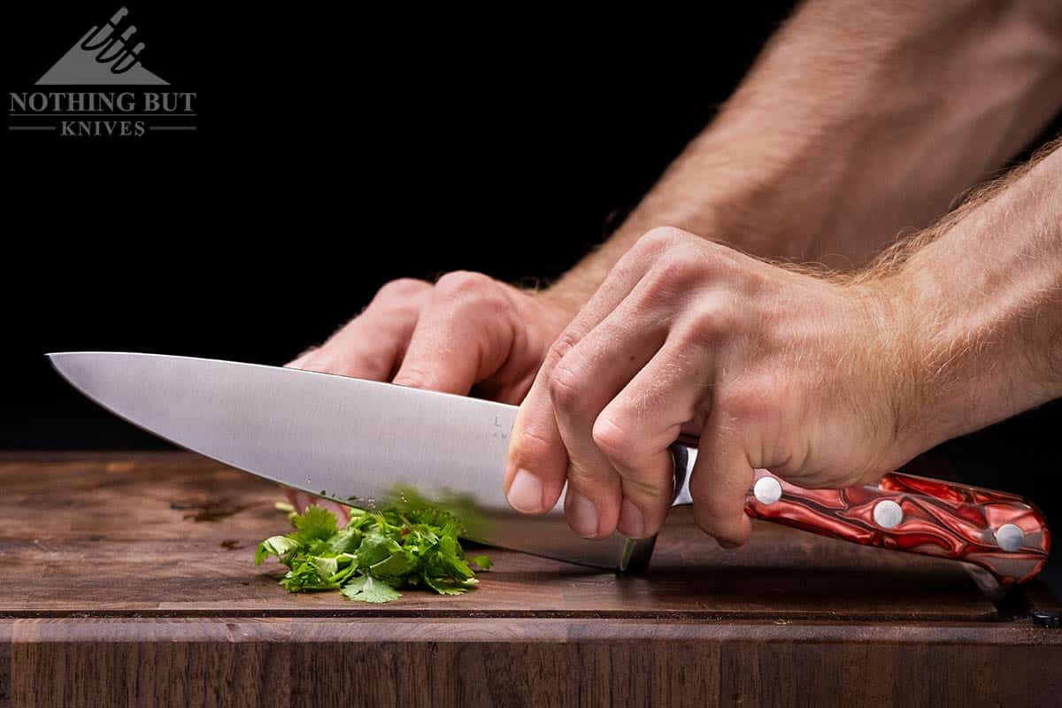 https://www.nothingbutknives.com/wp-content/uploads/2021/07/Chopping-Herbs-With-The-Lamson-Premier-FIre-Forged-Chef-Knife.jpg