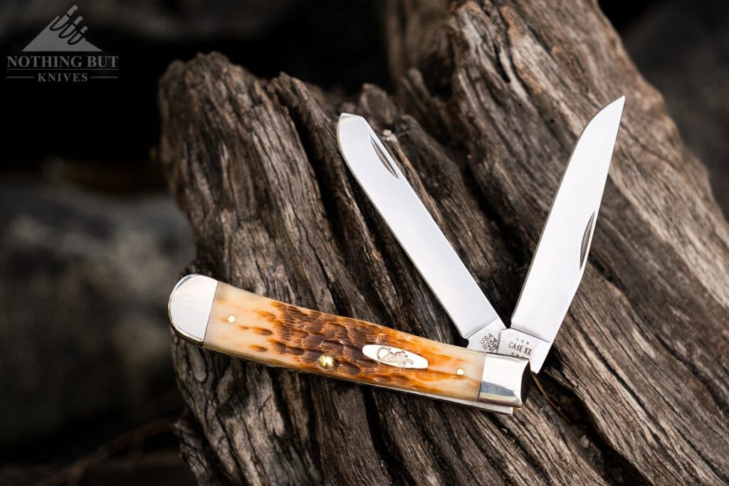 An overhead view of the Case Trapper with both blades partially open on top of a piece of weathered driftwood. 