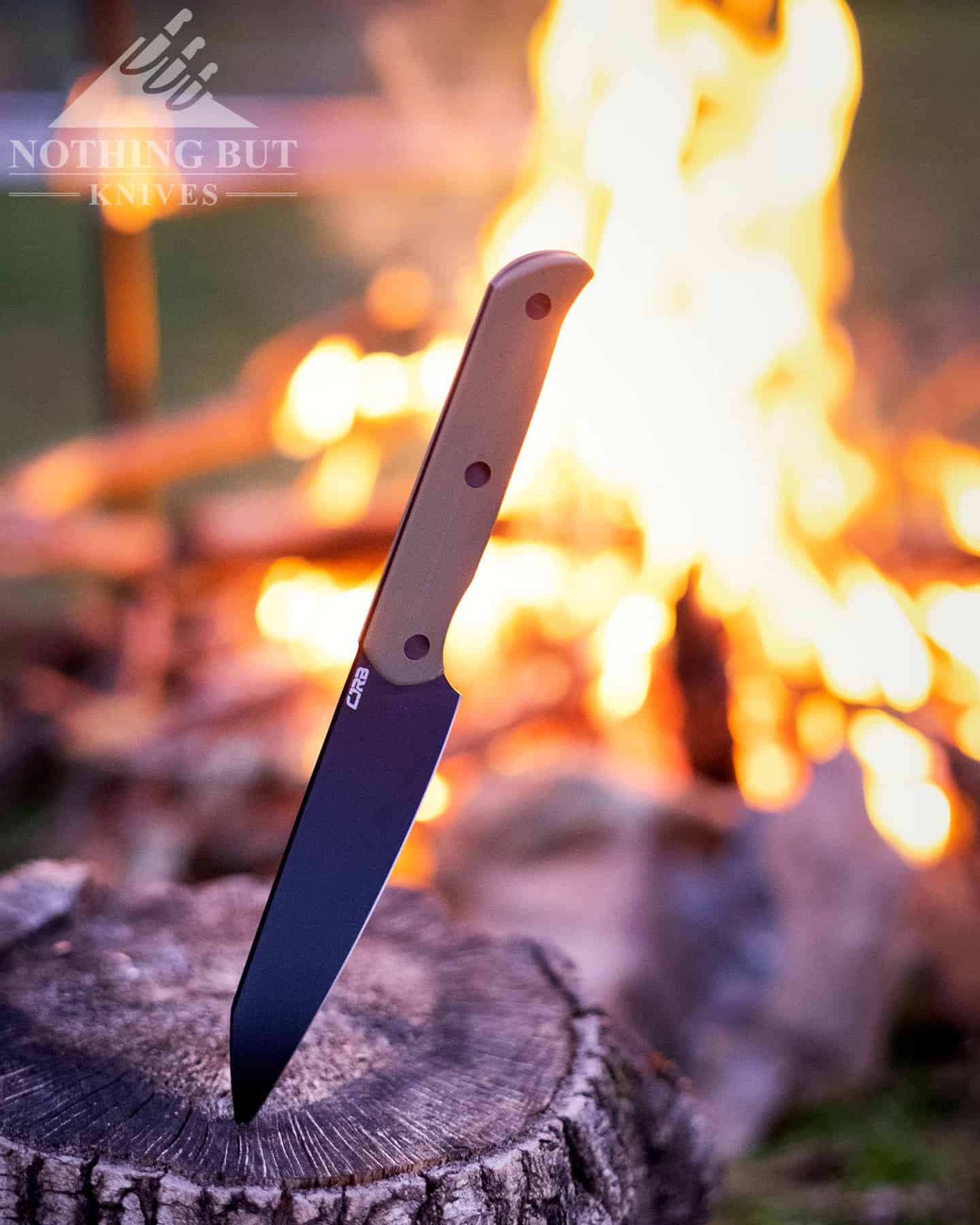 The CJRB Silax fixed blade knife next to a campfire that will be used to cook food the knife prepared.