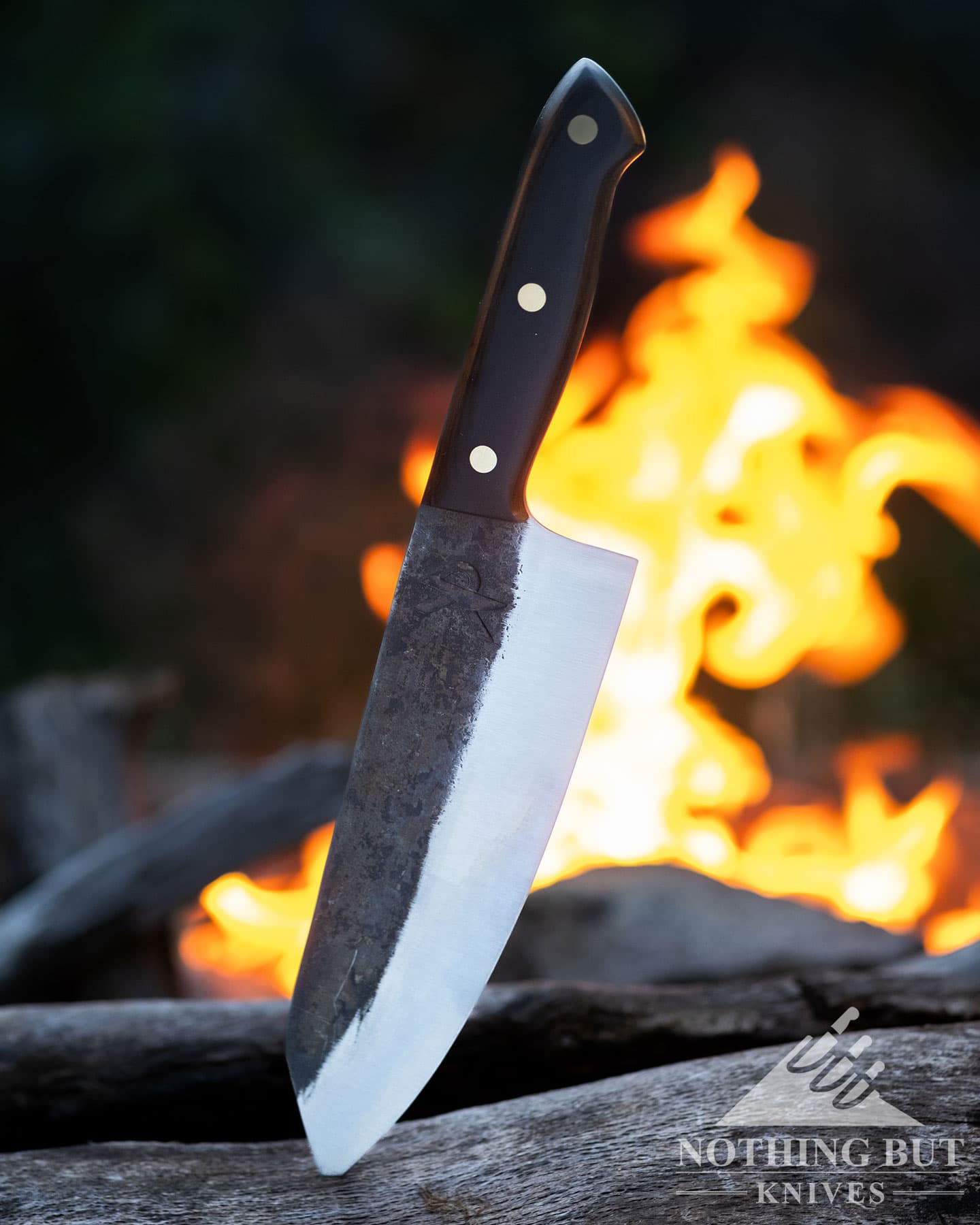 The Kitchen Perfection chef knife next to a campfire.
