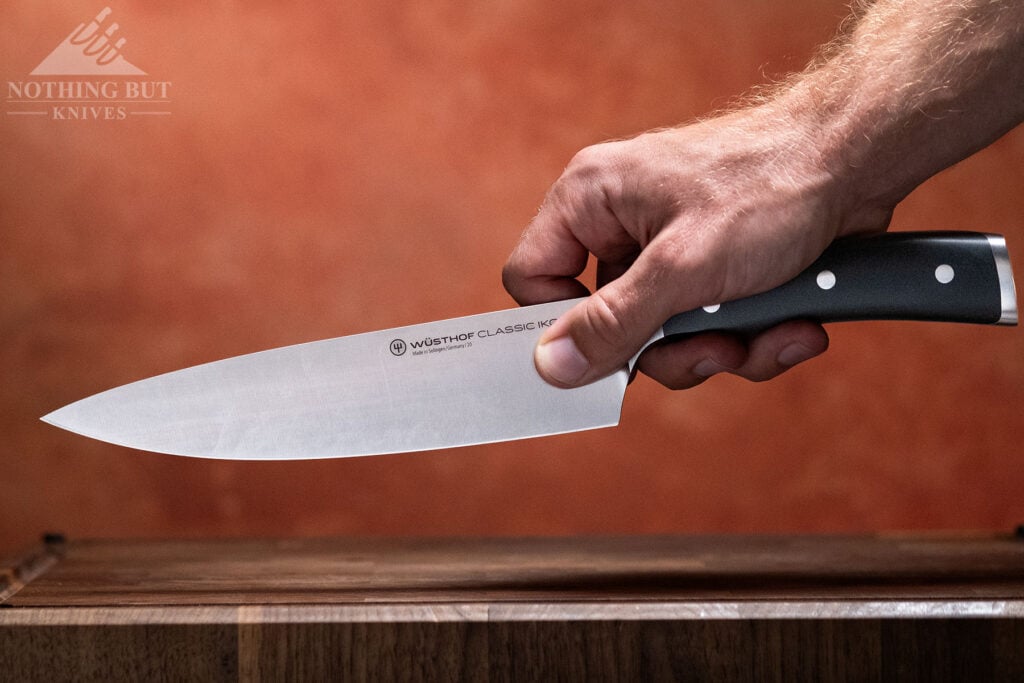 The Wusthof CLassic Ikon 8 inch chef knife being held in a pinch grip.