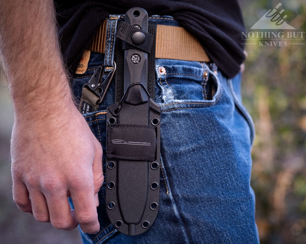 A close-up of the Ka-Bar Commando Clip Point knife in its kydex sheath on a person's hip. 