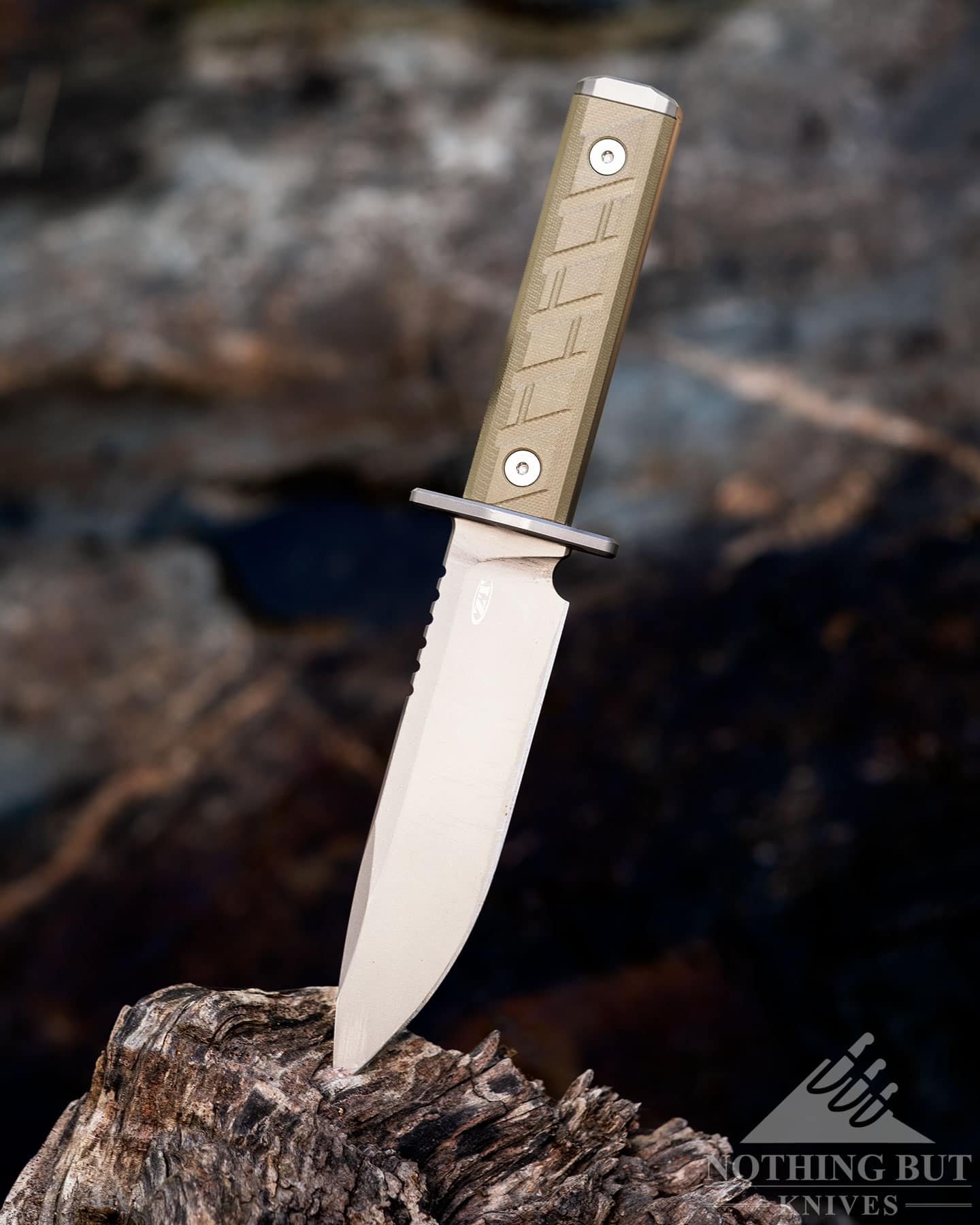 The Zero Tolerance 0006 survival knife sticking out of a large piece of driftwood.