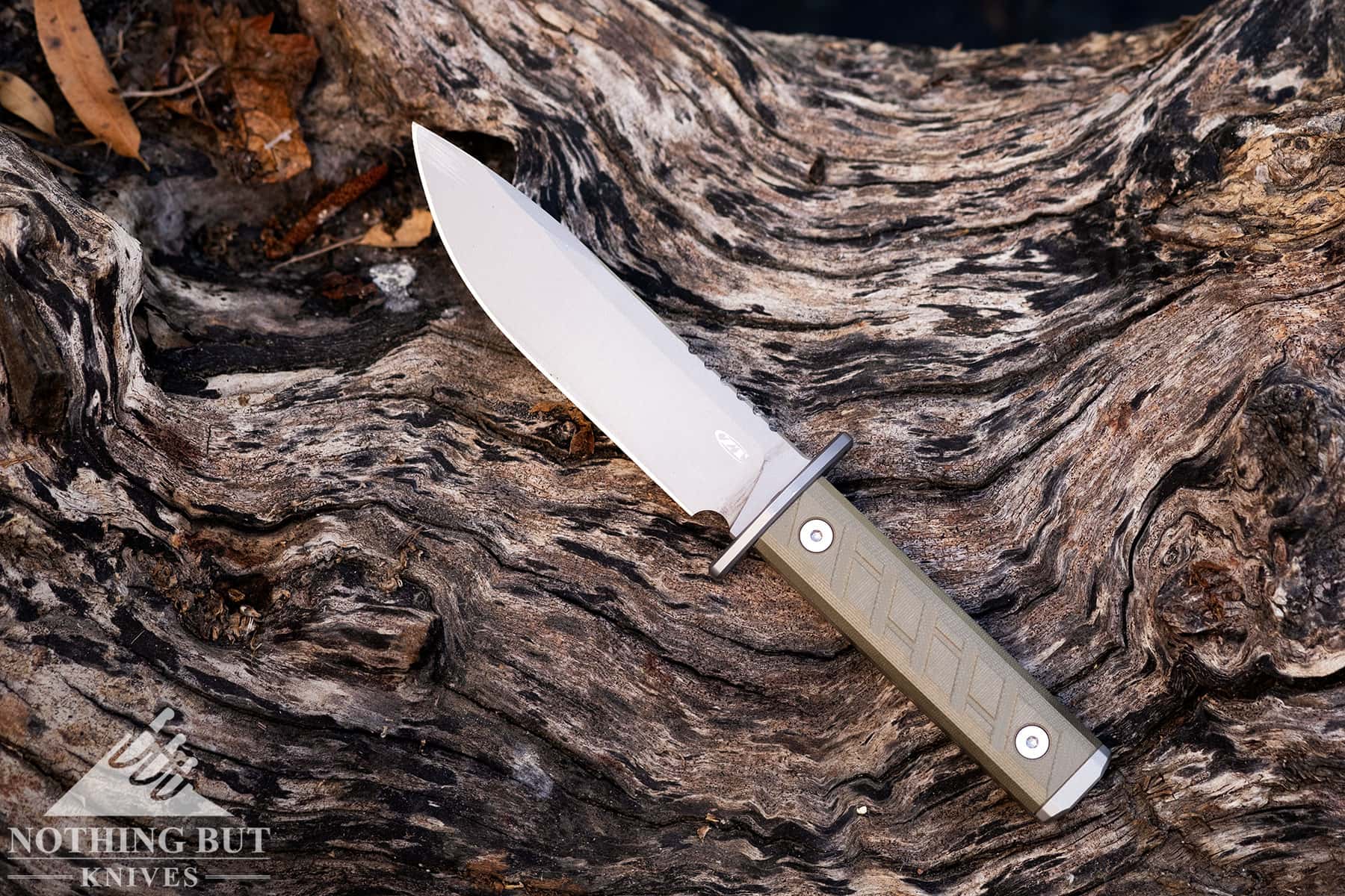 The Zero Tolerance 0006 fixed blade knife sitting on weathered wood outdoors.