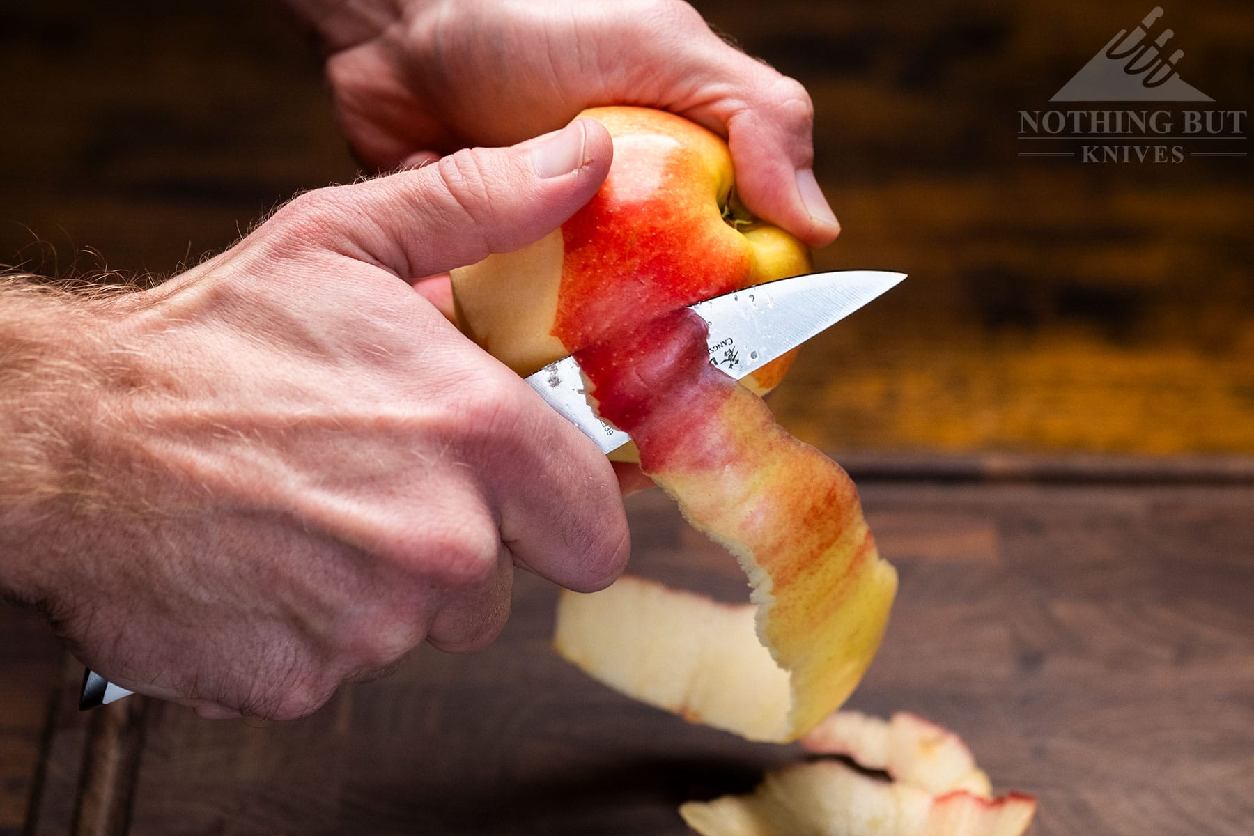 A close-up of an apple being peeled with the Cangshan Helena paring knife.