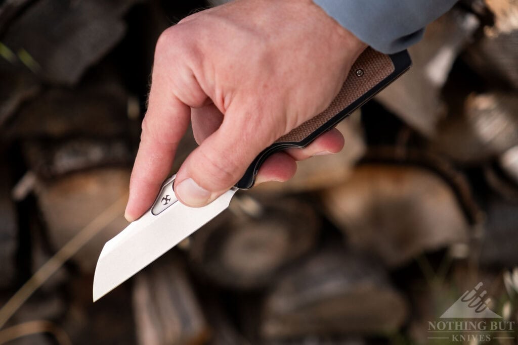 A hand utilizing the Tuckamore's tall blade with a pinch grip.