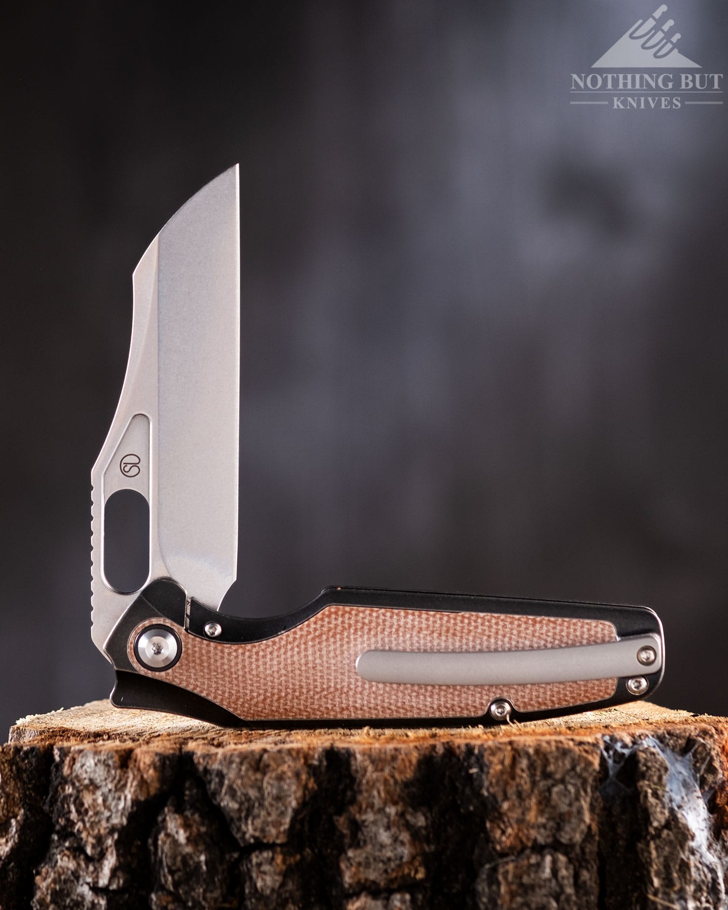 The Kansept Tuckamore's CPM 20v steel blade shows off on top of a log.