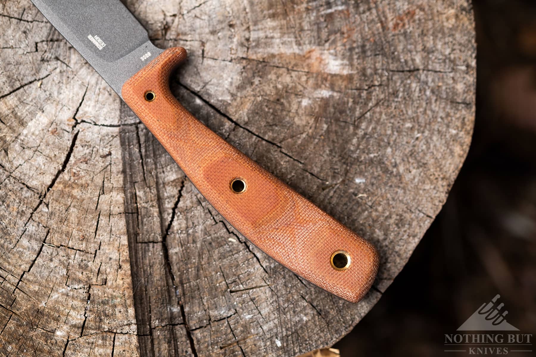 A close-up shot of the CRKT Soldotna handle on a tree stump.