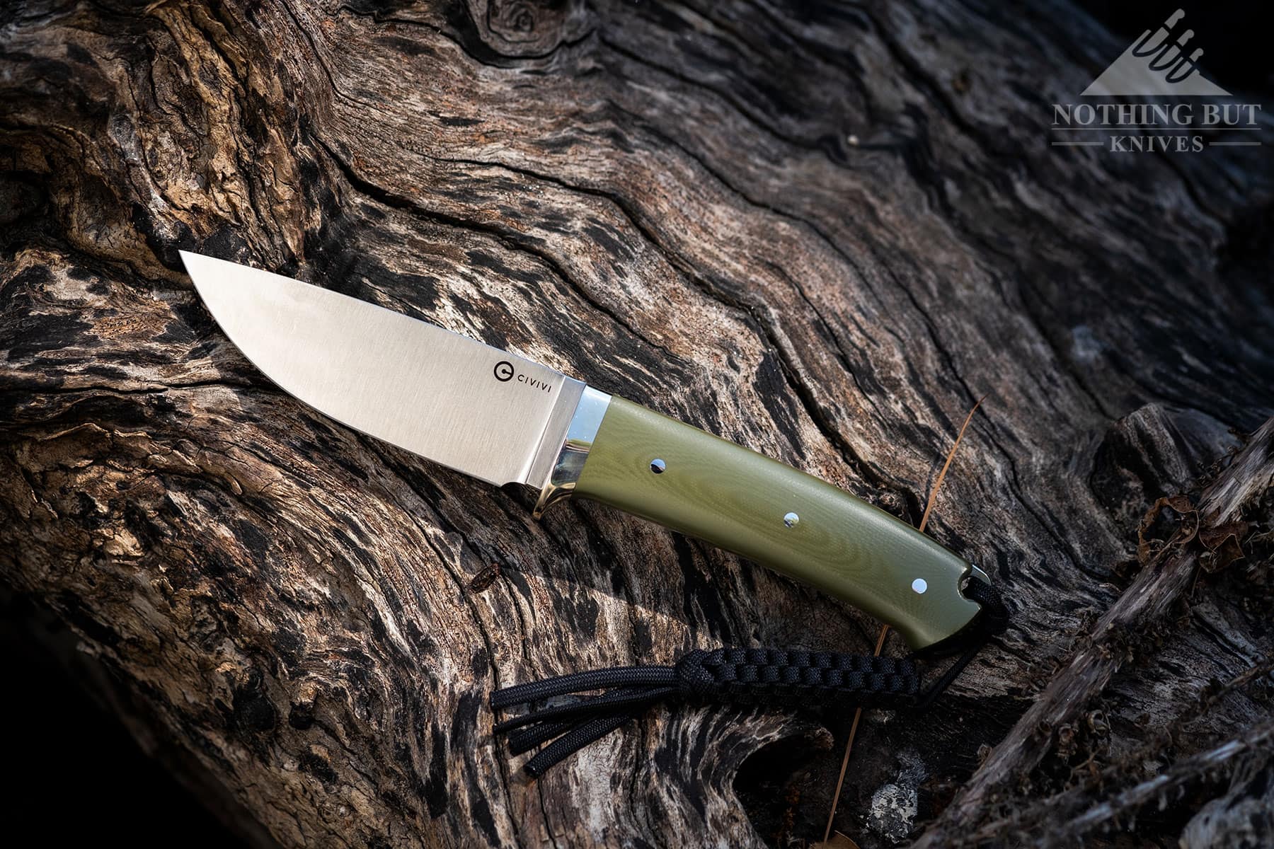 An overhead view of the Civivi Cloud Peak hunting knife on a log in a forest.