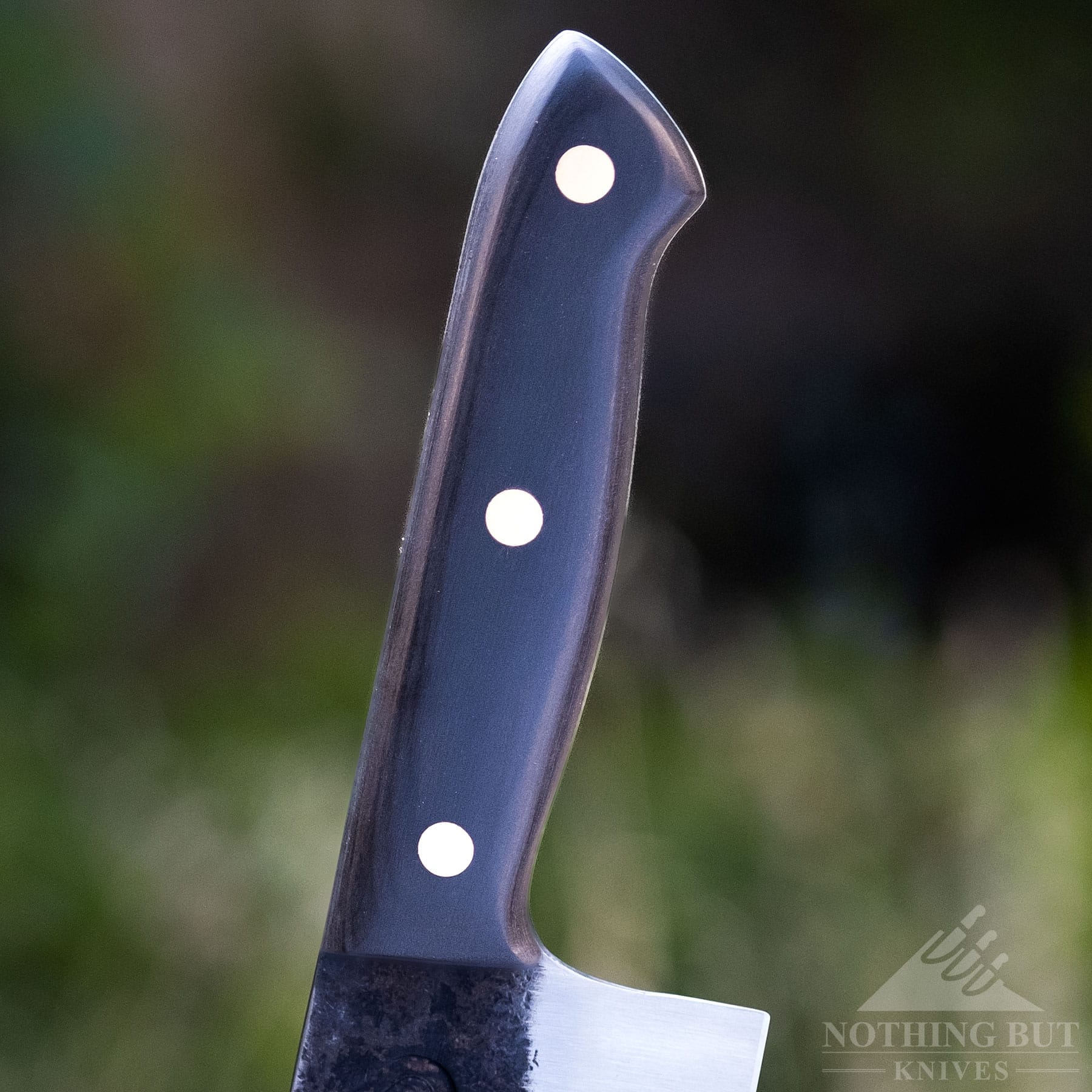 A shallow depth of field image of the Kitchen Perfection chef knife handle.