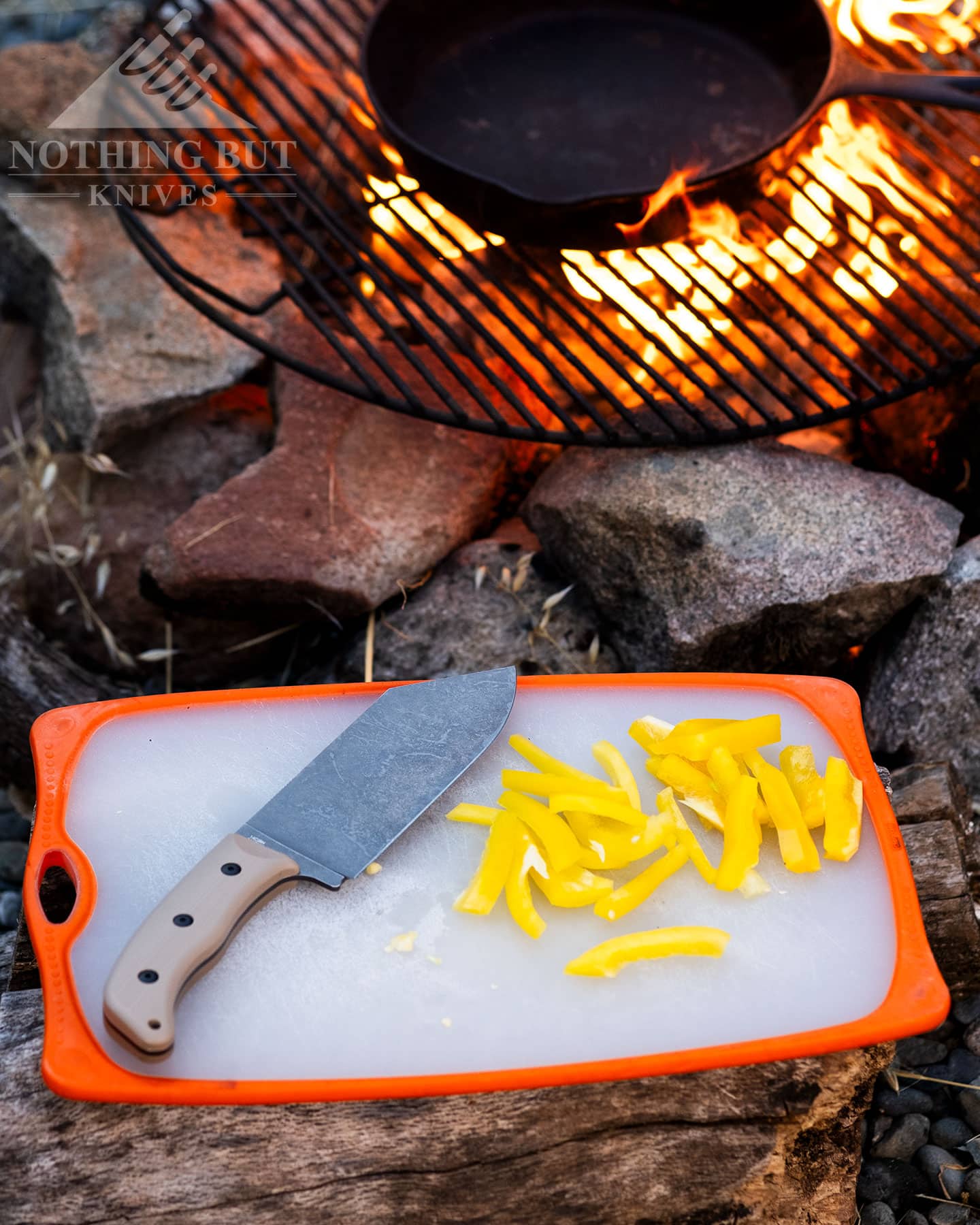 The Off-Grid Grizzly shown here with cut pieces of bell pepper next to a campfire.