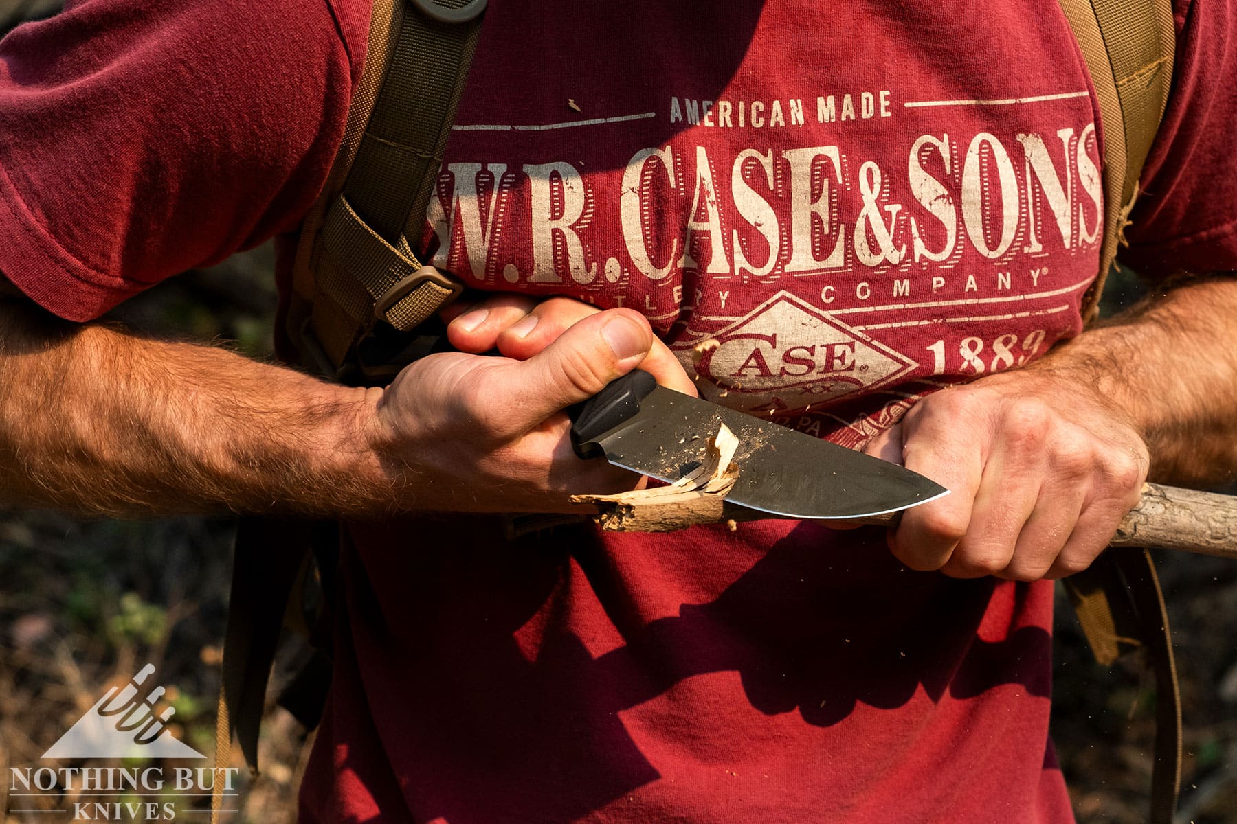 The Schwarz Knives Lost trail 5 fixed blade knife being used in the chest lever grip to carve a piece of wood.