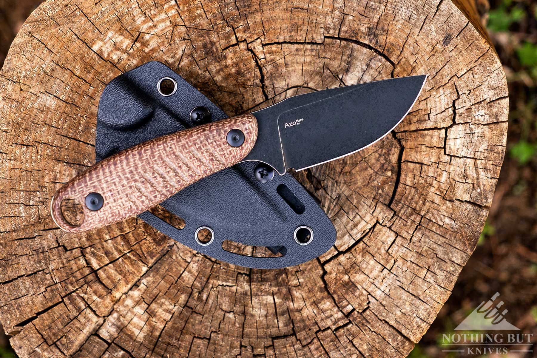 The Kizer Hare on top of its kydex sheath outdoors. 