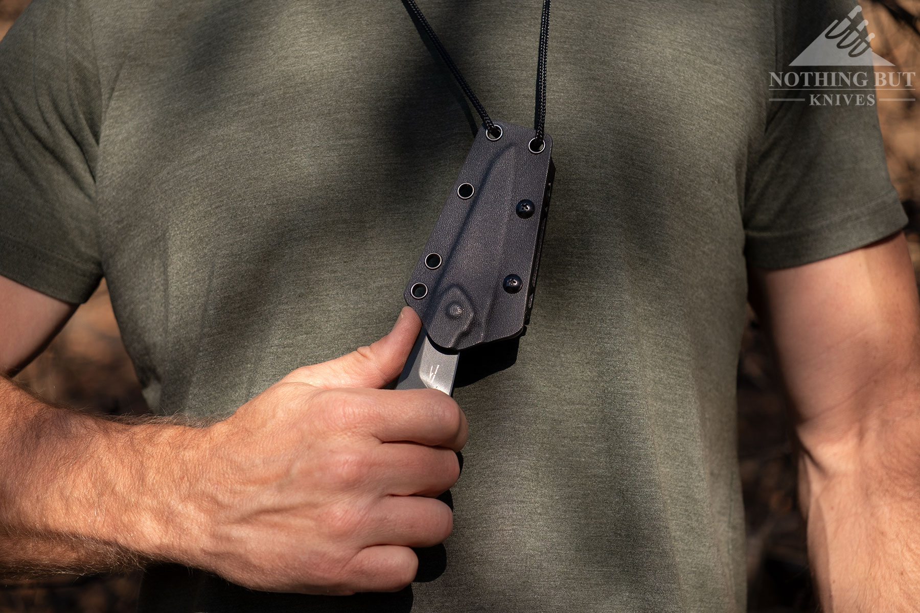 A close-up of the Kizer Groom on a lanyard hanging from a person's neck. 