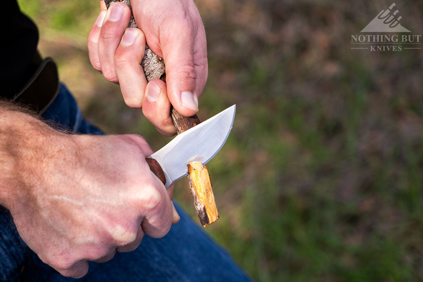 An overhead view of the Condor Mountaineer Trail Wingman knife being used to carve a stick. 