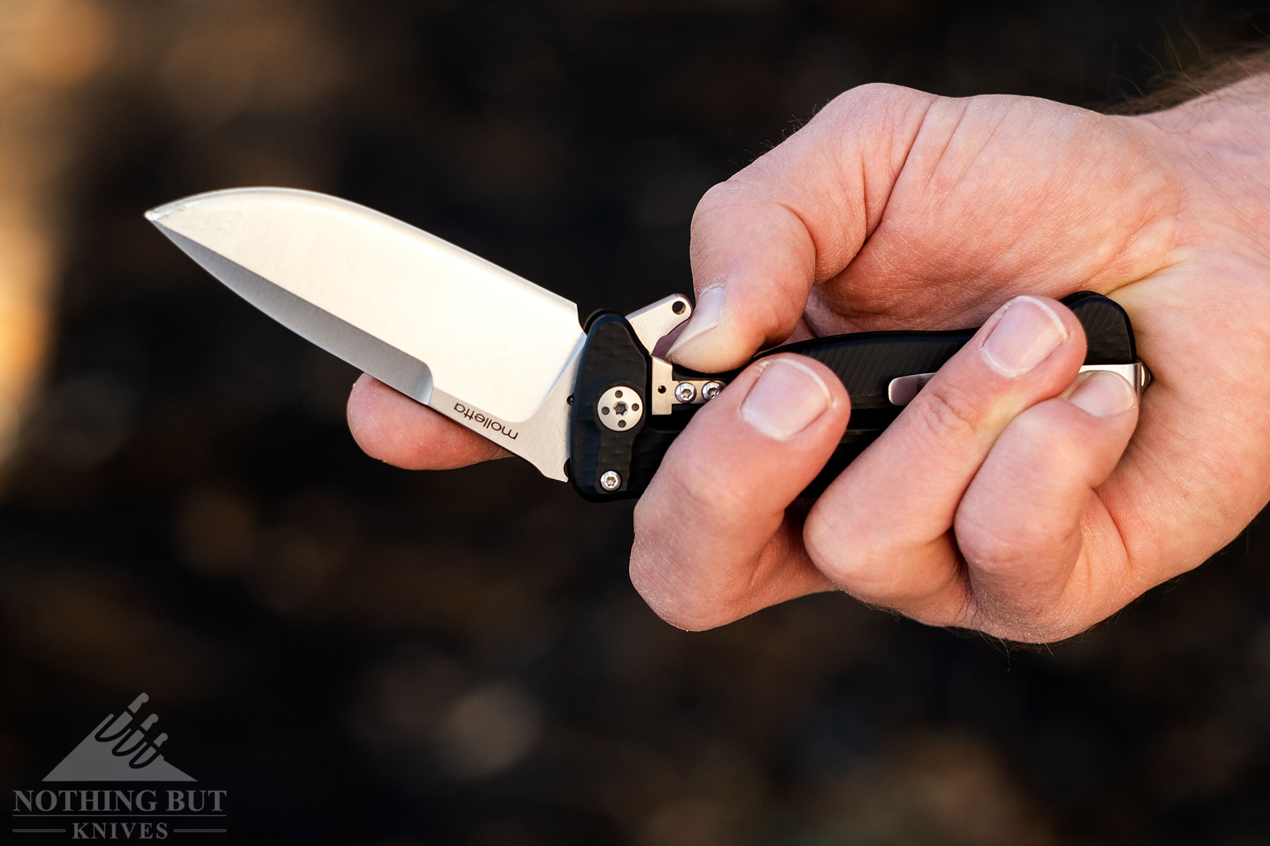 A close-up of the LionSteel SR22 folding knife being closed with one hand. 