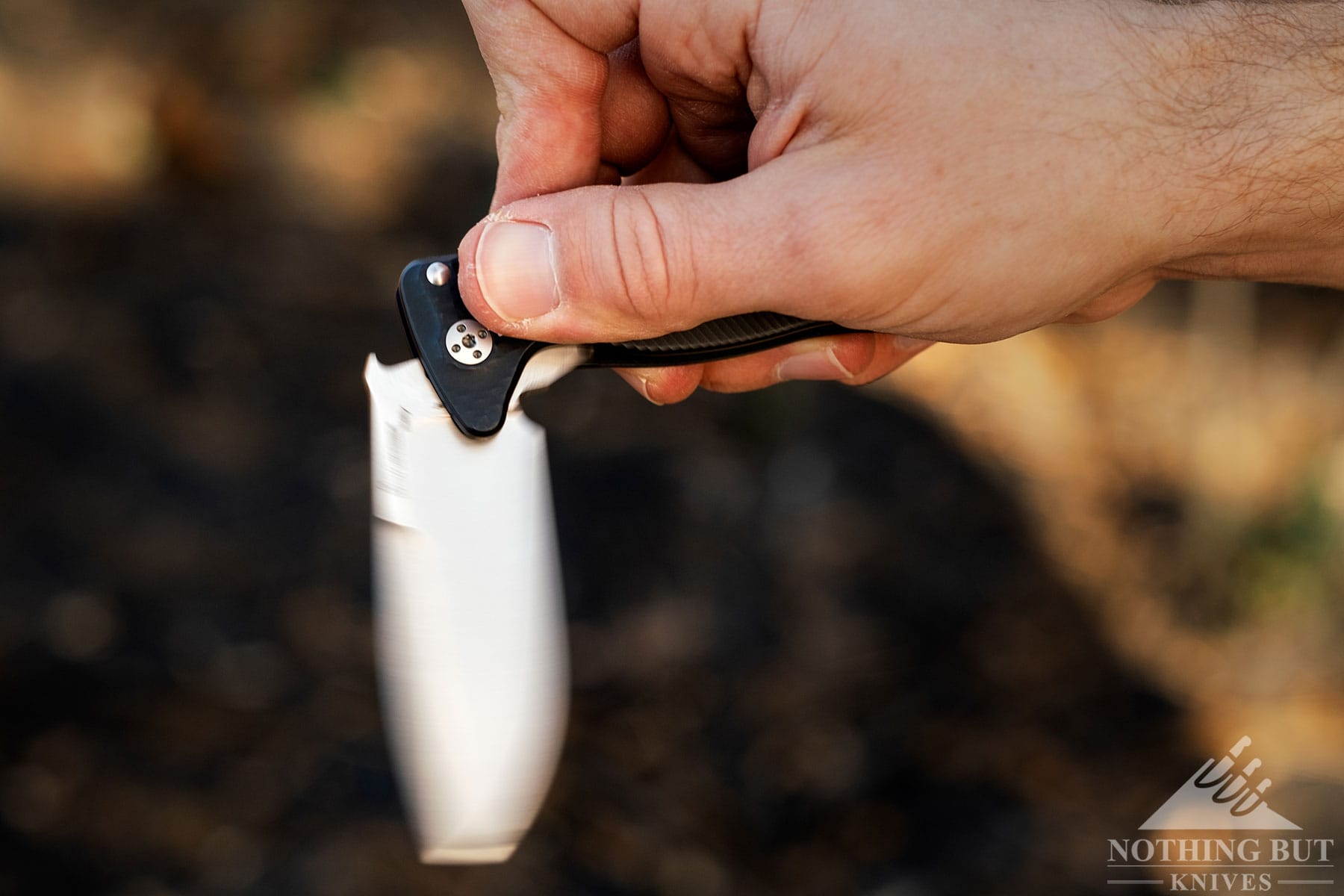 An action shot of the LionSteel SR22 pocket knife being flipped open with a person's index finger. 