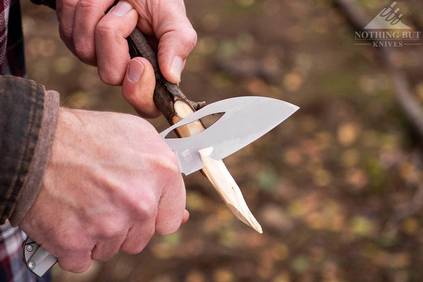 The Kizer Hawk folding knife being used to sharpen a stick. 