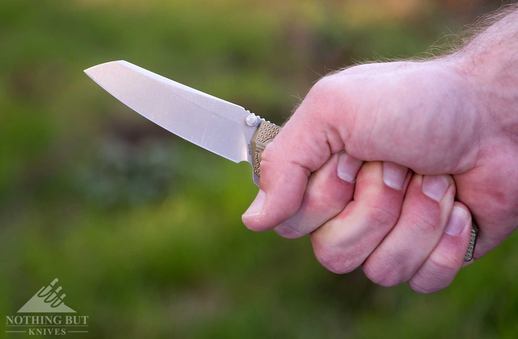 A close-up of the Oknife XEN-Oal folding knife being gripped in a person's hand to show handle scale and ergonomics.