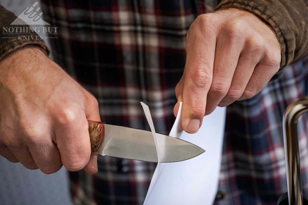 A close-up of the paper test being performed on a knife that was just sharpened on the Tomek T-4 knife sharpener. 