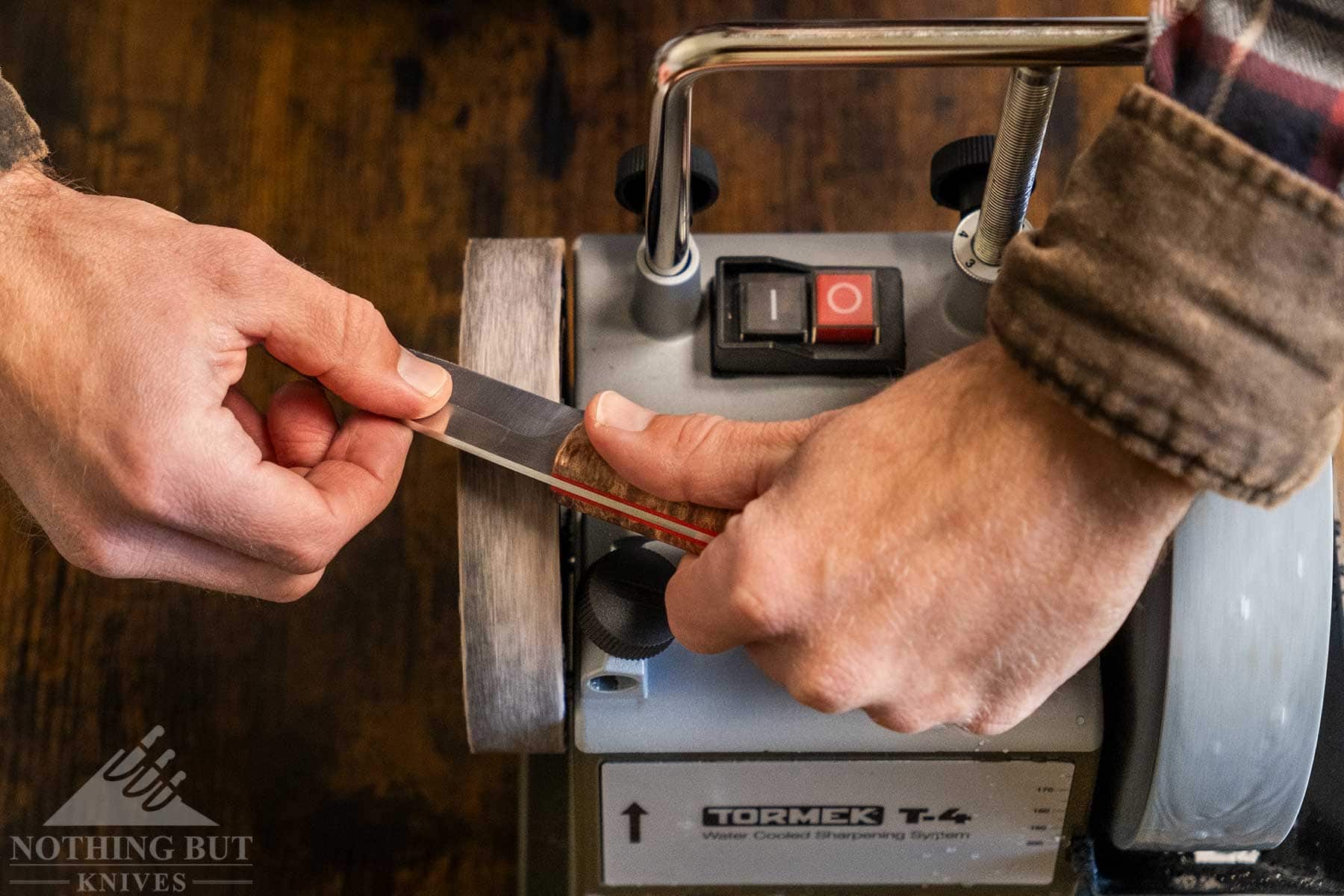 An overhead view of a fixed blade knife being honed with the honing wheel on the Tormek T-4 honing wheel. 